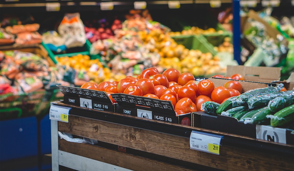 tomatoes in boxes on a shelf in a grocery store