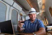 a man sitting at a desk with a glass of wine